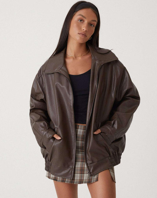 model draagt oversized losse leren jasje met rits sluiting rokje en hemd zwart leren biker jacket